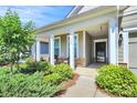 Inviting covered front porch with stone accents and charming seating area at 174 Hanks Bluff Dr, Mooresville, NC 28117