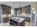 Well-equipped gray kitchen with island seating, modern appliances, and stylish pendant lights at 18125 Sulton Terrace Dr, Huntersville, NC 28078
