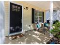 Inviting covered front porch with seating area, perfect for enjoying the outdoors at 18629 Coachmans Trce, Cornelius, NC 28031
