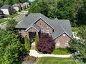 An aerial view shows a brick home with mature landscaping and tree coverage in a residential neighborhood at 201 Vanderbilt Blvd, Locust, NC 28097