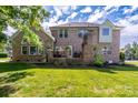 Brick home with back patio, green lawn, mature trees, and lush landscaping at 201 Vanderbilt Blvd, Locust, NC 28097