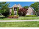 Traditional brick home with manicured front lawn, mature trees, and colorful flowerbeds at 201 Vanderbilt Blvd, Locust, NC 28097
