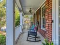 Inviting covered porch with classic rocking chairs and a ceiling fan for relaxing outdoors at 2301 Keara Way, Charlotte, NC 28270