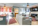 Bright open-concept living room with fireplace, hard wood flooring, lots of natural light, and adjoined kitchen at 23128 Goose Down Ln, Lancaster, SC 29720