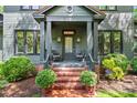 Inviting covered front porch with brick steps and seating area, perfect for relaxing outdoors at 2329 Club Rd, Charlotte, NC 28205