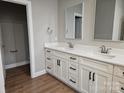 Bright bathroom featuring a double vanity with white cabinets and hard wood floors at 2442 Falcon Ln, Statesville, NC 28625
