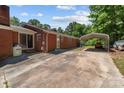 Expansive backyard featuring a brick home, a detached carport and a paved driveway at 24501 Canton Rd, Albemarle, NC 28001