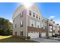 Two-story townhome featuring gray siding, a brick foundation, an attached two-car garage, and a well-maintained lawn at 2665 Grantham Place Dr, Fort Mill, SC 29715