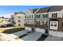 Exterior view of townhomes with attached two-car garages, gray siding, and well-manicured lawns on a sunny day at 2665 Grantham Place Dr, Fort Mill, SC 29715