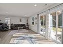 Bright living room with hardwood floors, modern furniture, and a sliding glass door leading to an outdoor area at 2665 Grantham Place Dr, Fort Mill, SC 29715