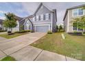 Well-maintained two-story home with blue siding, manicured lawn and a two-car attached garage at 3022 Burnello Ct, Iron Station, NC 28080
