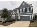 Attractive two-story home featuring a blue exterior, black shutters, two-car garage, and manicured landscaping at 3022 Burnello Ct, Iron Station, NC 28080