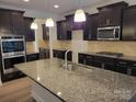 Spacious kitchen island, granite countertops and stainless steel appliances at 3022 Burnello Ct, Iron Station, NC 28080