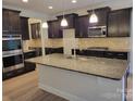 Granite countertops, stainless appliances, and ample storage highlight this open concept kitchen at 3022 Burnello Ct, Iron Station, NC 28080