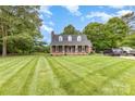 Charming brick home with a well-manicured lawn, mature trees, and a long driveway, perfect for a peaceful living at 3049 Stablegate Dr, Gastonia, NC 28052