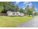 Well-maintained single-story home featuring an expansive lawn and mature trees on a sunny day at 403 Carpenter Parker Ln, Rock Hill, SC 29730