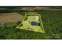 Aerial view of the home's acreage with pond, surrounded by mature trees and open fields at 4111 Jenkins Rd, Marshville, NC 28103