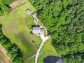Acreage home with lush lawn, outbuildings and a pond surrounded by mature trees at 4111 Jenkins Rd, Marshville, NC 28103