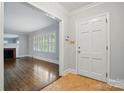 Bright foyer leading to living room with hardwood floors and fireplace; tiled entry floor at 4220 Castlewood Rd, Charlotte, NC 28209