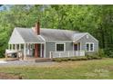 Well-maintained single-story home with a covered porch, brick chimney, and landscaped front yard at 500 Peigler Nw St # Lots 1 & 2, Concord, NC 28027