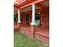 Covered front porch with classic columns, a rocking chair, and a welcoming entrance at 514 N Main St, Mount Gilead, NC 27306