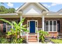 Inviting home featuring a bright blue front door, brick steps, and lush tropical landscaping at 5418 Commodore Pl, Clover, SC 29710