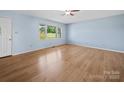 Bright living room with light blue walls, hardwood floors, and a large window at 55 Dixie Dr, Taylorsville, NC 28681