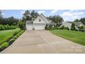 View of the exterior featuring a long driveway and manicured front lawn at 6309 Fawn Crest Dr, Waxhaw, NC 28173