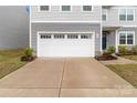 Spacious two car garage with a large concrete driveway and manicured flowerbeds at 703 Pointe Andrews Dr, Concord, NC 28025