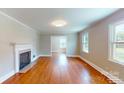 Bright living room showcasing hardwood floors, a fireplace, and abundant natural light from large windows at 7101 City View Dr, Charlotte, NC 28212