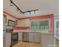 Bright kitchen featuring modern appliances, granite countertops, and track lighting at 7312 Barcliff Dr, Charlotte, NC 28212