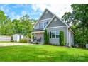 Charming gray home with mature trees, inviting front porch, and a spacious green lawn at 8024 Eagle St, Mount Pleasant, NC 28124