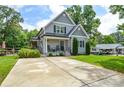 Two-story home with gray siding, mature trees, a spacious driveway, and a well-maintained lawn at 8024 Eagle St, Mount Pleasant, NC 28124