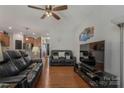 Cozy living room with hardwood floors, modern sofas, entertainment center, and open view into the kitchen at 8031 Scarlet Oak Ter, Indian Land, SC 29707