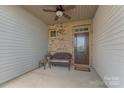 Inviting porch showcasing a brick wall, door with glass panes, bench seating, and a welcoming atmosphere at 8031 Scarlet Oak Ter, Indian Land, SC 29707