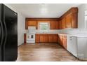 Kitchen features wood cabinets, white appliances, vinyl floor, and natural lighting at 804 Gw Broome Rd, Monroe, NC 28112