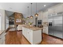 Open-concept kitchen with a center island, stainless appliances, and seamless flow to the living room at 8701 Highgrove St, Charlotte, NC 28277