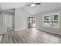Sunlit living room showcasing vaulted ceilings, gray vinyl plank flooring, and an open entryway to the home's exterior at 894 Oval St, Kannapolis, NC 28081
