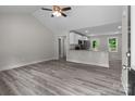 Bright and airy living room with vaulted ceilings, gray vinyl plank flooring, and an open view of the kitchen at 894 Oval St, Kannapolis, NC 28081