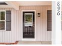 Close-up view of the front door with decorative black shutters and brick trim at 896 Oval St, Kannapolis, NC 28081