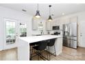 Bright kitchen with stainless steel appliances, center island with seating, and white cabinets at 9157 Snow Hill Ct, Charlotte, NC 28269