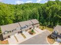 An aerial view showcases townhouses with well-kept lawns in a peaceful, wooded setting at 9203 Grand Valley Dr, Charlotte, NC 28213