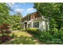 Beautiful home featuring classic brickwork, a white balcony, and mature trees surrounding the property at 1139 S Belvedere Ave, Gastonia, NC 28054