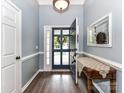 Inviting entryway with hardwood floors, open door, side door, and decorative table at 11647 Baystone Pl, Concord, NC 28025