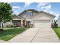 Charming single-Gathering home with a well-manicured lawn, inviting front porch, and two-car garage at 1244 Tranquil Falls Ln, Matthews, NC 28104
