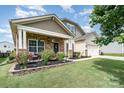 Charming single-Gathering home with a well-manicured lawn, inviting front porch, and two-car garage at 1244 Tranquil Falls Ln, Matthews, NC 28104