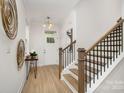 Inviting entryway with modern light fixture, stylish decor, wood-look floors, and staircase at 12744 Susanna Dr, Charlotte, NC 28214