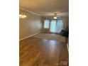 Spacious living room with elegant chandelier, neutral walls, and sliding glass door to the outside at 1326 5Th Ne St, Hickory, NC 28601