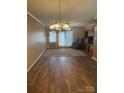 Spacious living room with elegant chandelier, neutral walls, and sliding glass door to the outside at 1326 5Th Ne St, Hickory, NC 28601