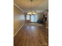 Spacious living room with elegant chandelier, neutral walls, and sliding glass door to the outside at 1326 5Th Ne St, Hickory, NC 28601